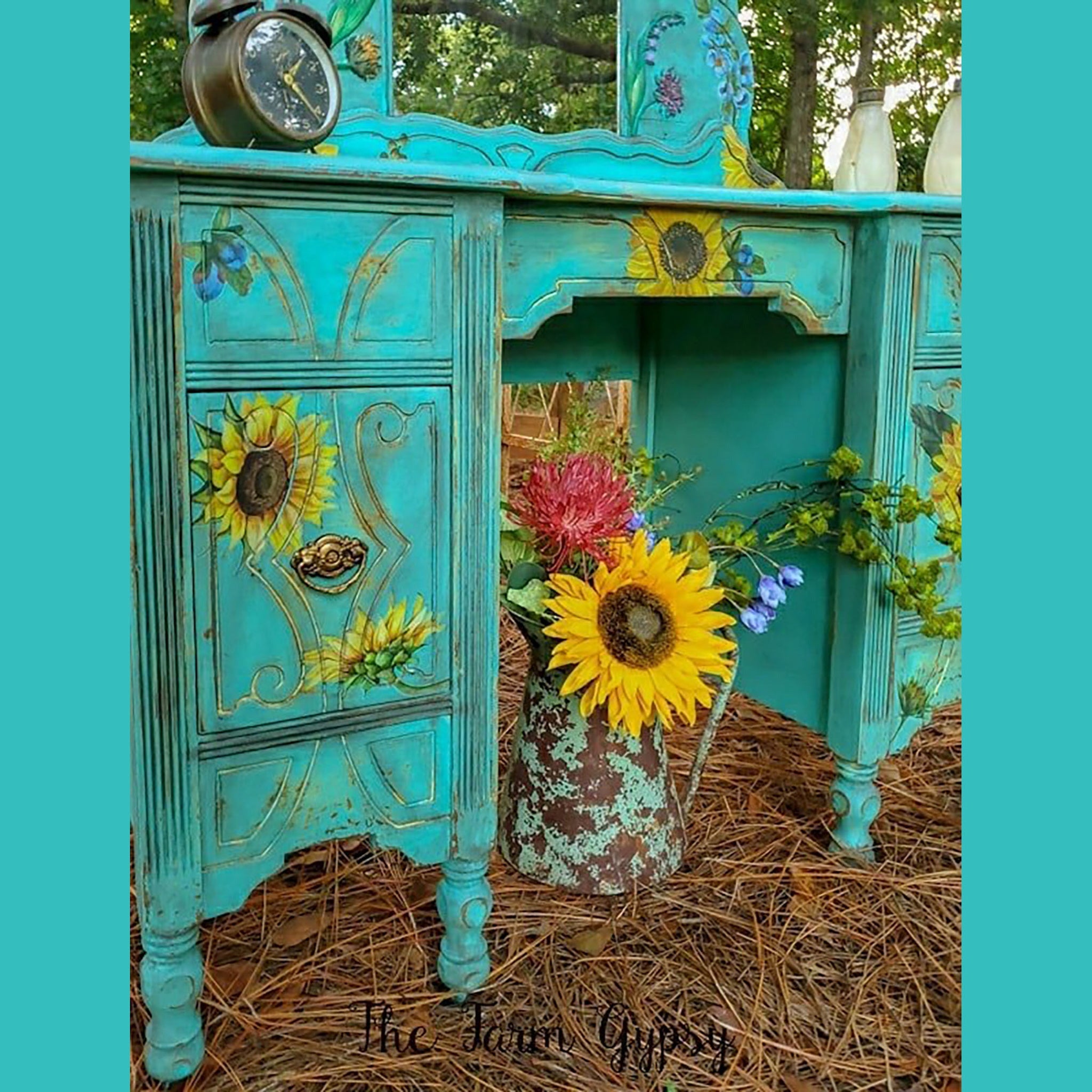 A vintage vanity refurbished by The Farm Gypsy is painted light teal and features the Sunflowers Transfer on it.