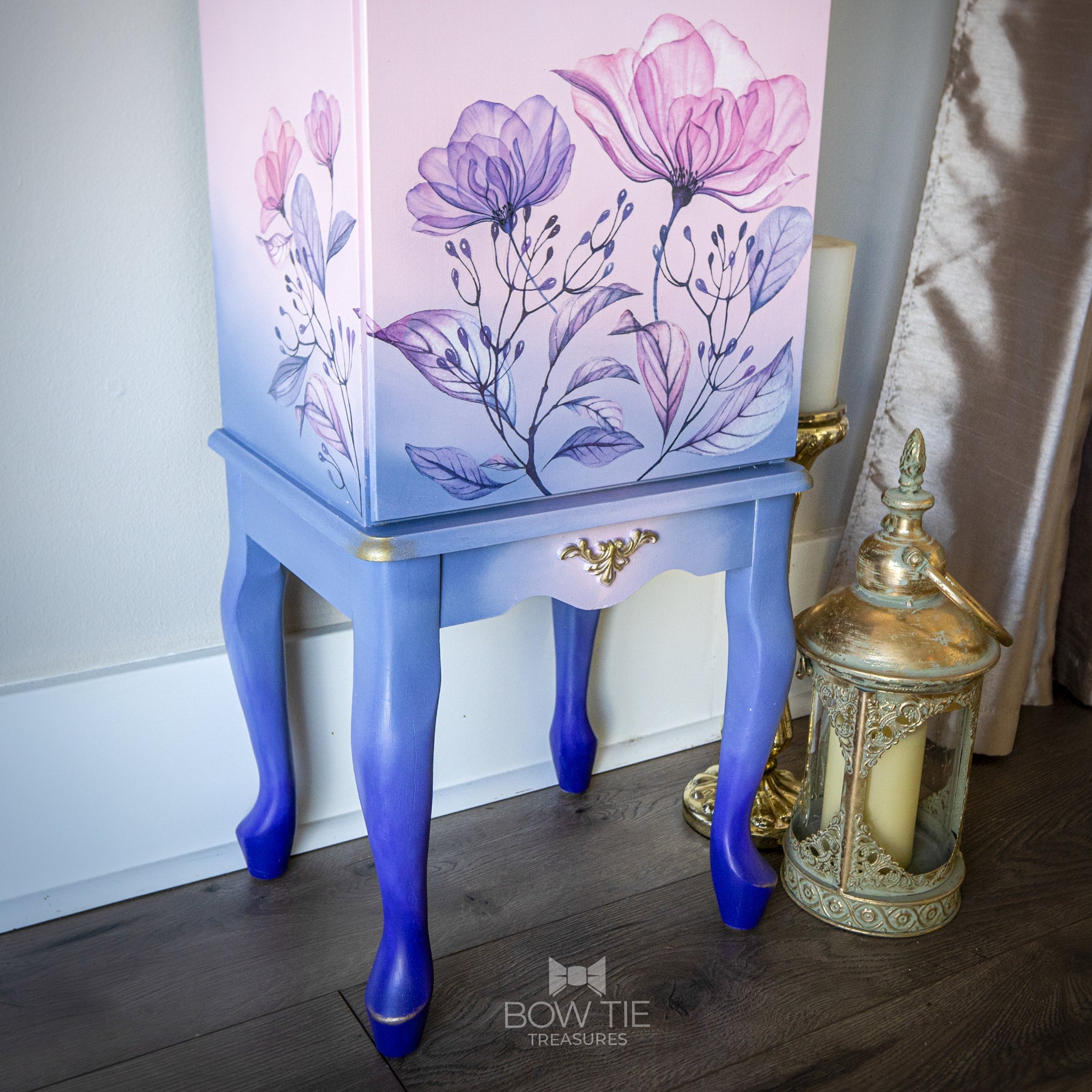 A close-up of a vintage standing jewelry box refurbished by Bow Tie Treasures is painted a blend of light pink and blue and features the Translucent Gardens Transfer on it.
