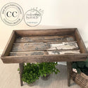 A vintage wood tray with legs refurbished by Redesign by Zold Copenhagen, a Dixie Belle Paint Company Content Creator, is finished in a natural wood stain and features the Vintage Post Transfer inside the tray.
