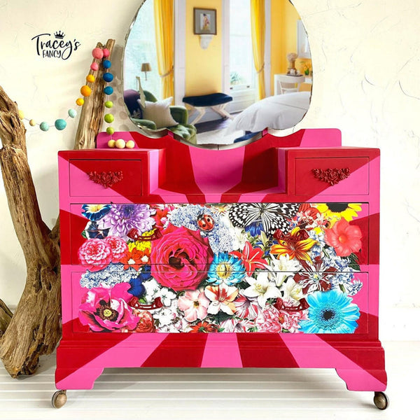 A vintage dresser refurbished by Tracey's Fancy is painted red and pink and features the Whimsical Wonderland Transfer on the front.
