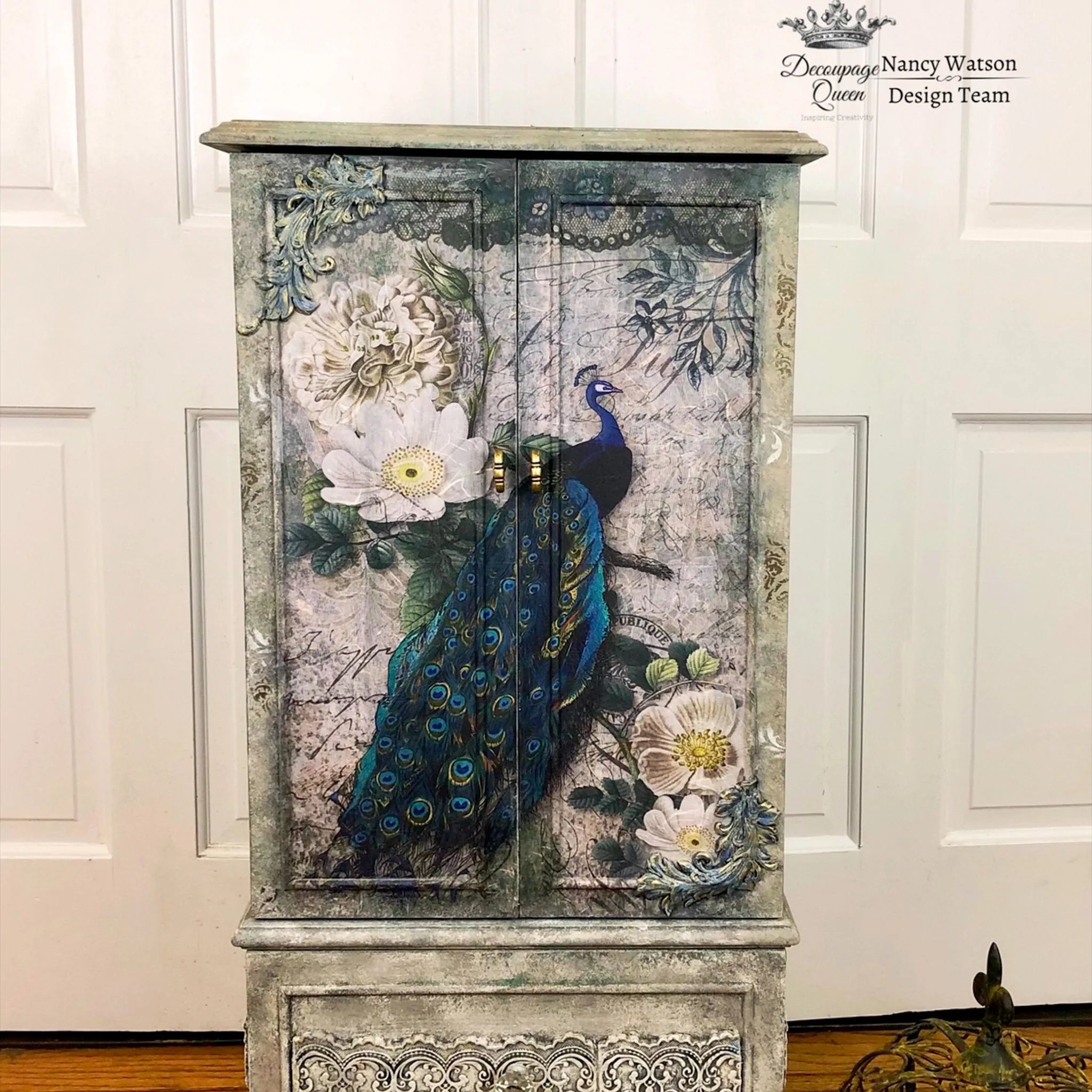 Rustic dresser with the Peacock Majesty decoupage paper on top. A Decoupage Queen and Nancy Watson Design Team logo on the top right.