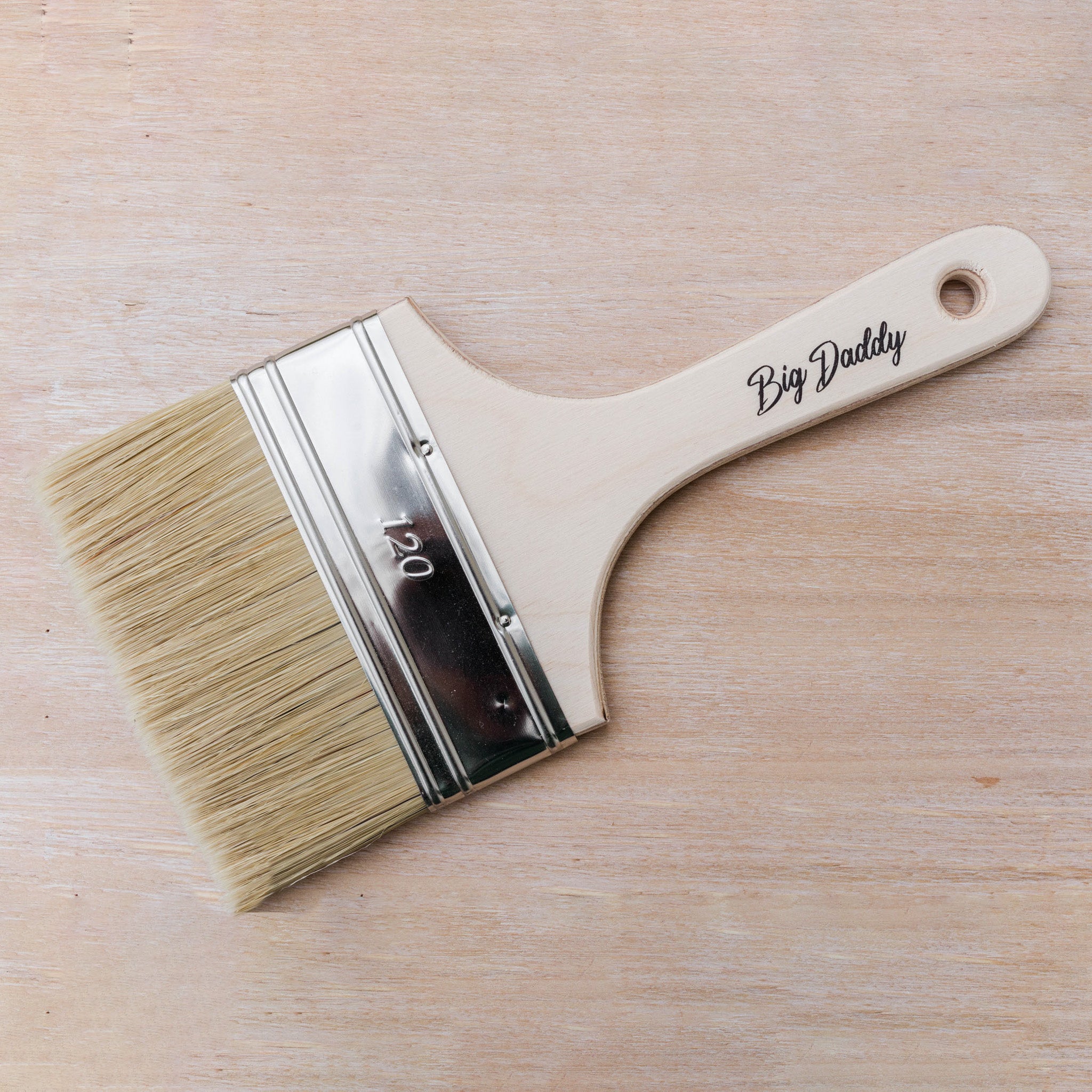 Dixie Belle Paint's Bid Daddy Brush is against a light wood background.