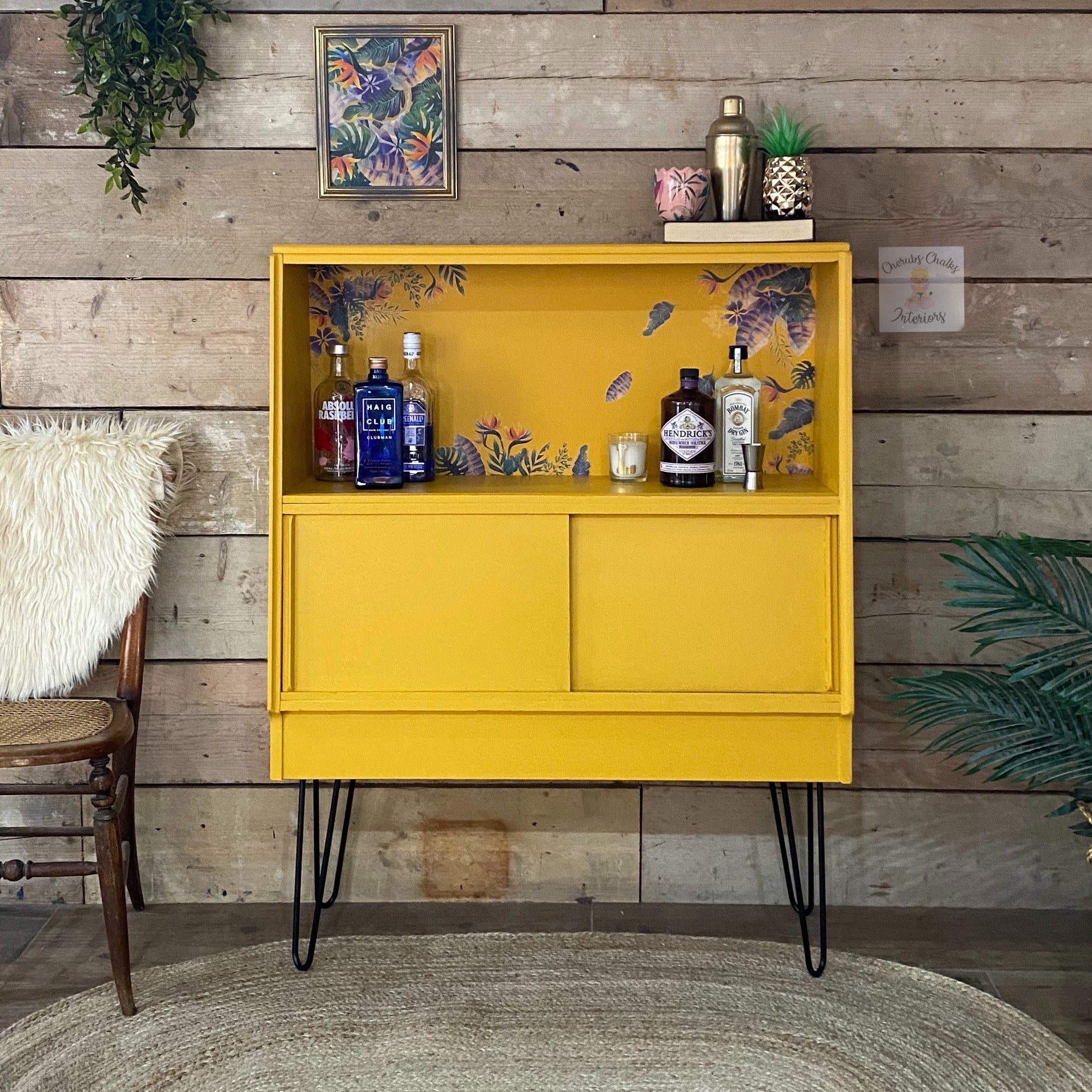 A mid-centure bar cabinet refurbished by Cherbs Chalks Interiors is painted in Dixie Belle's Colonel Mustard chalk mineral paint.