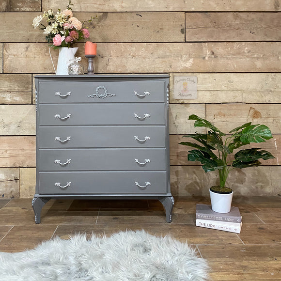 A vintage 5-drawer chest dresser refurbished by Cherubs Chalks Interiors is painted in Dixie Belle's Hurricane Gray chalk mineral paint.