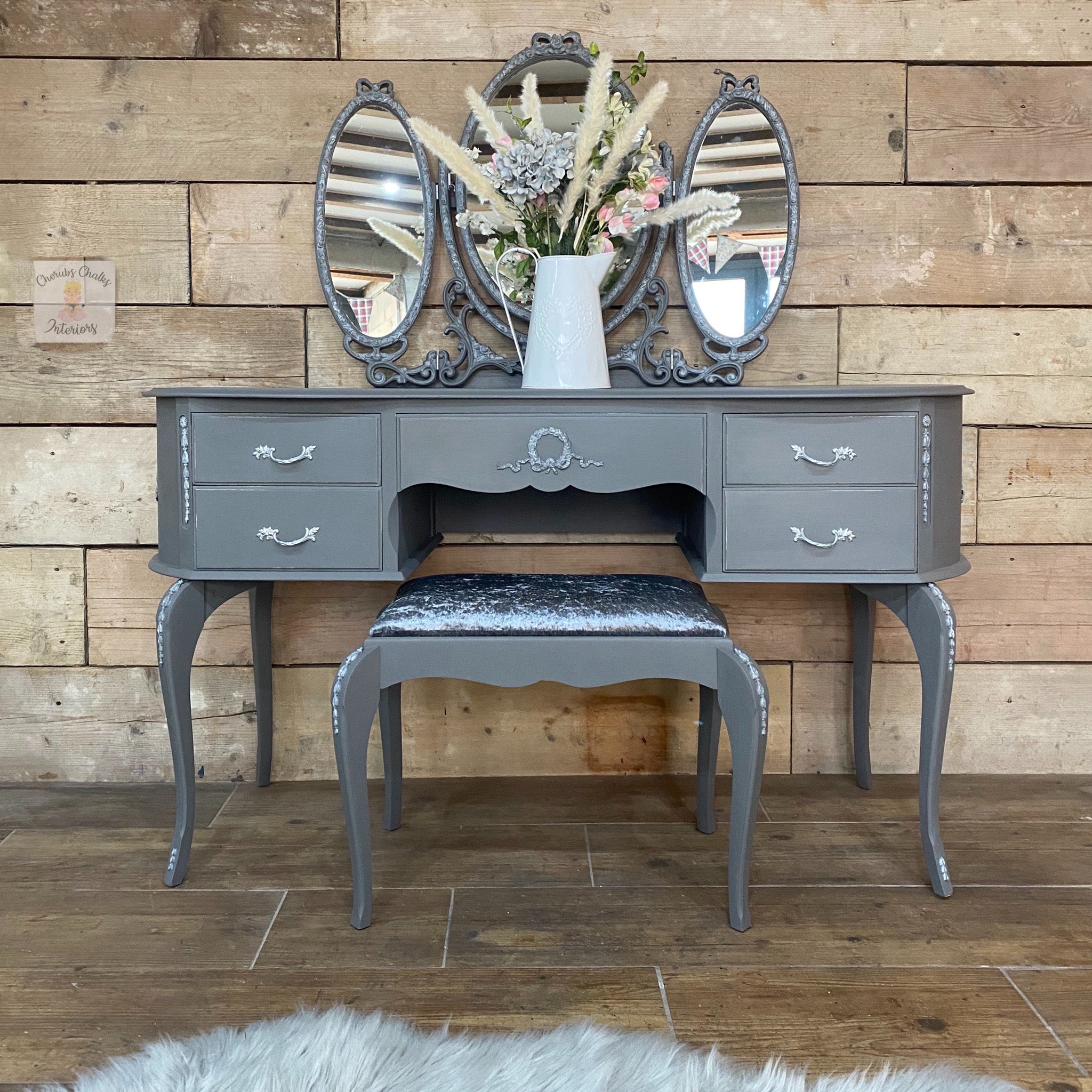 A vintage vanity desk, stool, and tri-fold mirror refurbished by Cherbs Chalks Interiors are painted in Dixie Belle's Hurricane Gray chalk mineral paint.