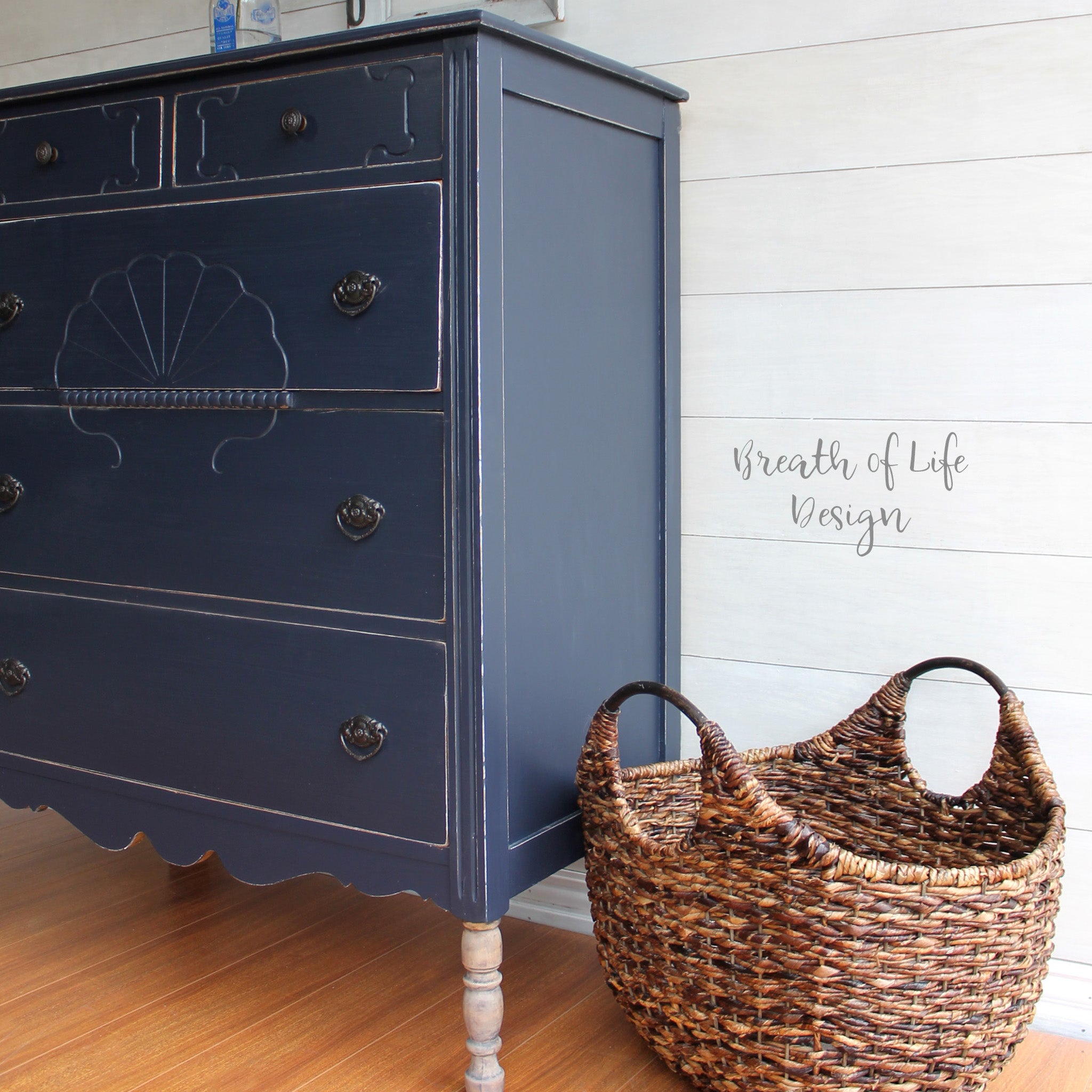 A close-up view of a 5-drawer dresser refurbished by Breath of Life Design is painted in Dixie Belle's In the Navy chalk mineral paint.