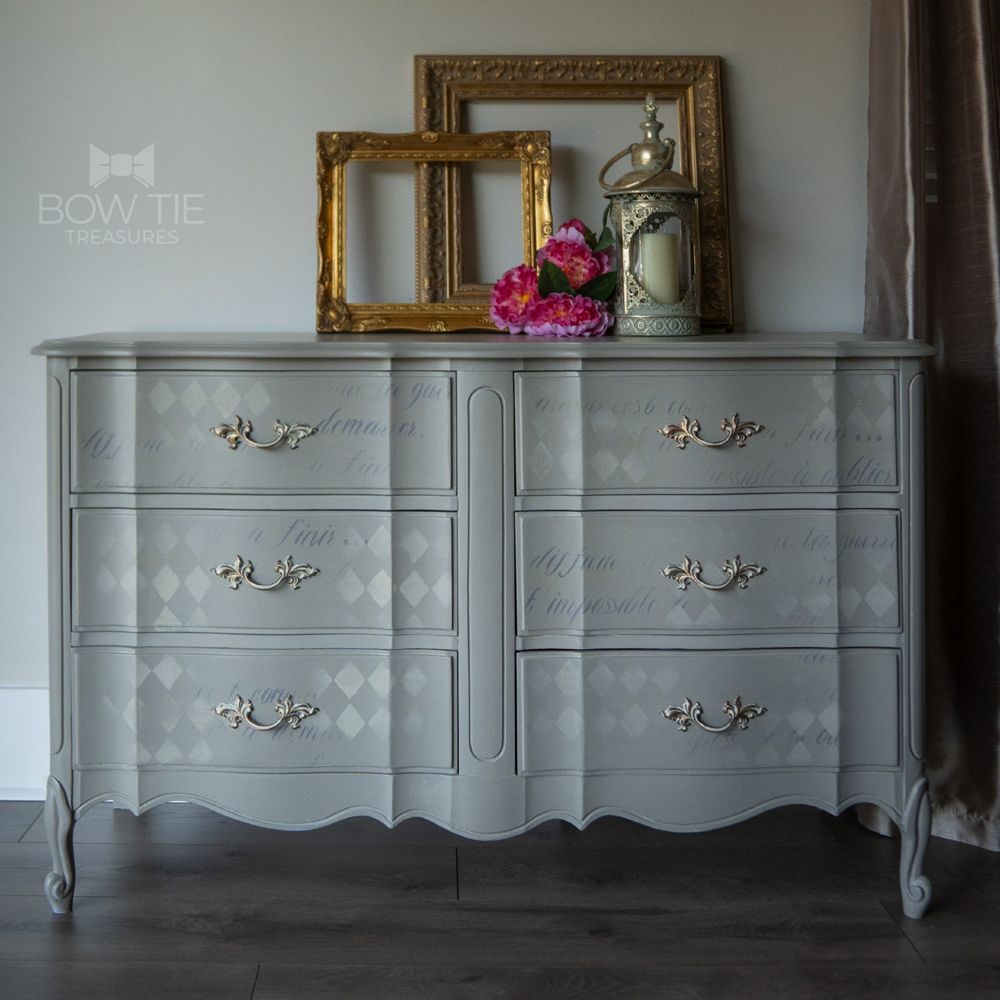 A vintage 6-drawer dresser refurbished by Bow Tie Treasure is painted in Dixie Belle's Mason Dixon chalk mineral paint and has a ghost painted Harlequin diamond pattern and faint script writing.