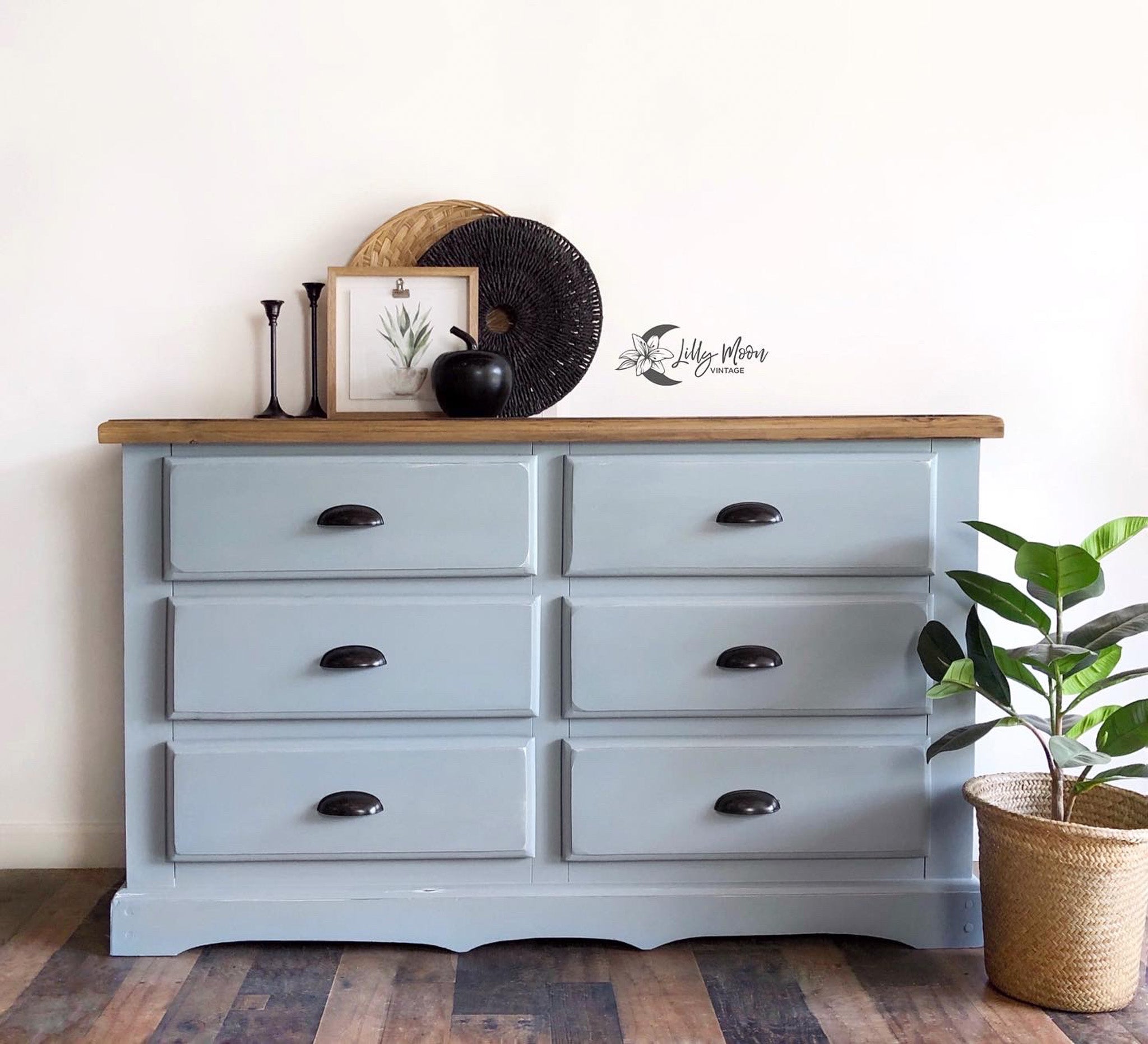 A 6-drawer dresser refurbished by Lilly Moon Designs is painted in Dixie Belle's Savannah Mist chalk mineral paint and has a natural wood top.