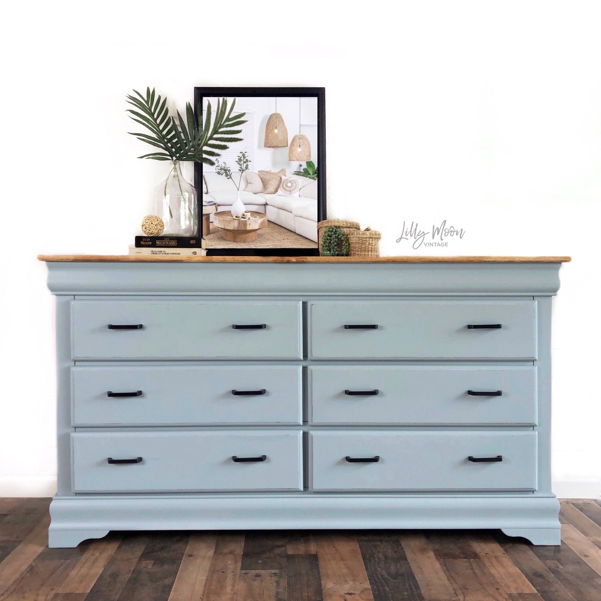 A 6-drawer dresser refurbished by Lilly Moon Designs is painted in Dixie Belle's Savannah Mist chalk mineral paint and has a natural wood top.