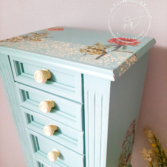 A vintage standing jewelry armoire refurbished by Vintage Revitalized by Tina Brown is painted in Dixie Belle's Sea Glass chalk mineral paint.