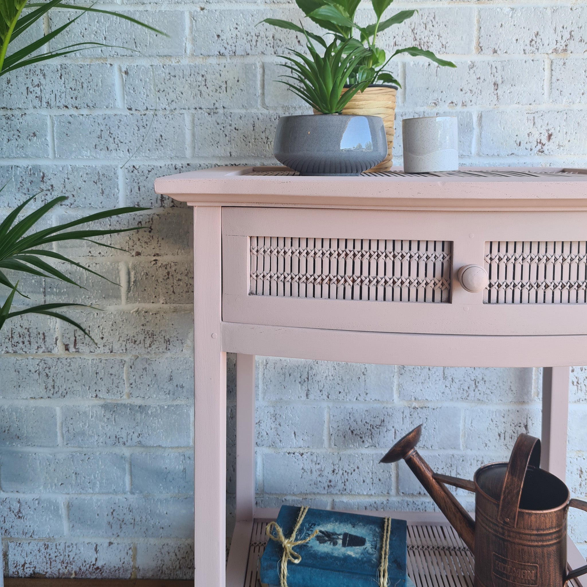 A vintage side table is painted in Dixie Belle's Soft Pink chalk mineral paint.