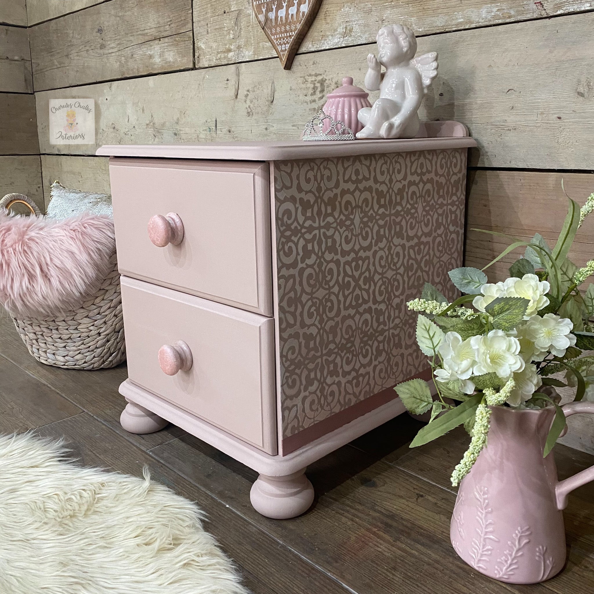 A vintage child's 2-drawer nightstand refurbished by Cherubs Chalks Interiors is painted in Dixie Belle's Soft Pink chalk mineral paint.
