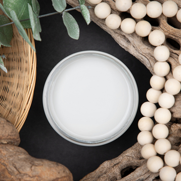 An arial view of an open container of Dixie Belle Paint Company’s Driftwood Chalk Mineral Paint is surrounded by a wood bead garland, driftwood, and a wicker basket.