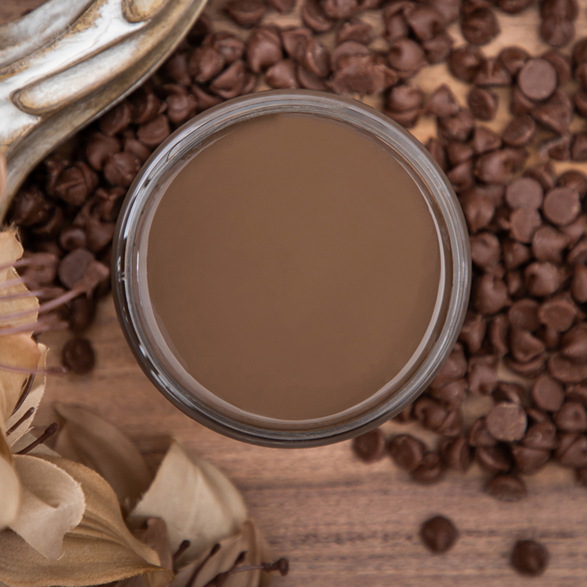 An arial view of an open container of Dixie Belle Paint Company's Chocolate Chalk Mineral Paint is surrounded by milk chocolate chips.