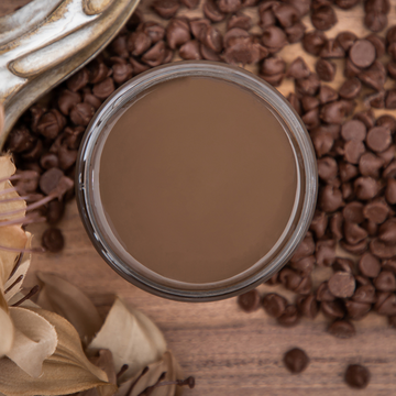 An arial view of an open container of Dixie Belle Paint Company's Chocolate Chalk Mineral Paint is surrounded by milk chocolate chips.