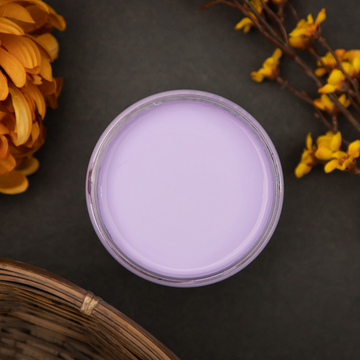 An arial view of an open container of Dixie Belle Paint Company’s Lucky Lavender Chalk Mineral Paint is surrounded by amber-colored silk flowers and a wicker basket.