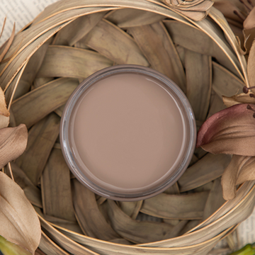 An arial view of an open container of Dixie Belle Paint Company’s Mud Puddle Chalk Mineral Paint is inside a wicker basket.