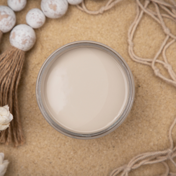 An arial view of an open container of Dixie Belle Paint Company’s Sand Bar Chalk Mineral Paint is surrounded by rope and wood beads.