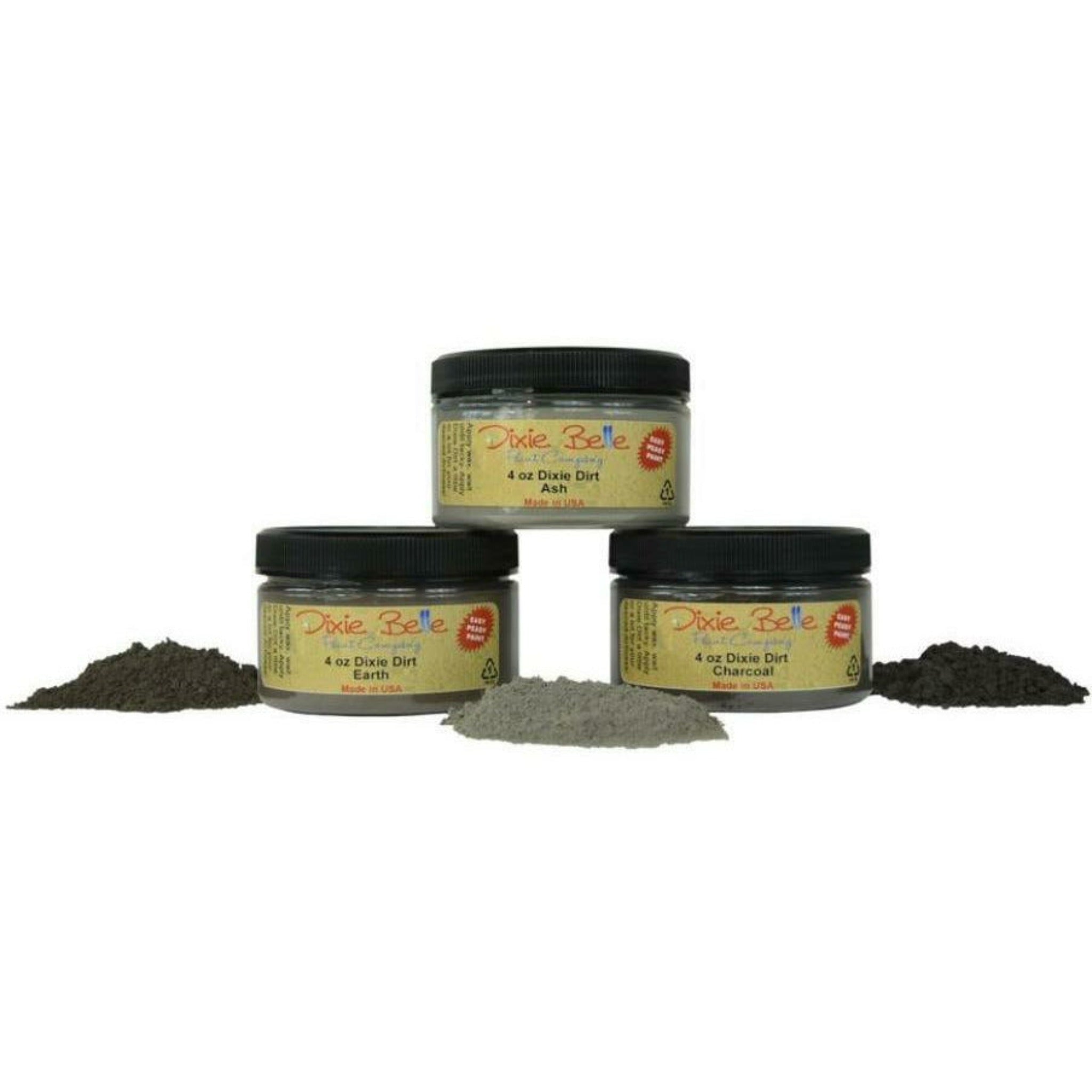 Three containers of Dixie Belle Paint Company's 4oz Dixie Dirt in Ash, Earth, and Charcoal are shown against a white background along with small piles of the product. These are loose pigments used to create shadowing and dimension to any furniture project.
