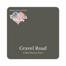 A square swatch card of Dixie Belle Paint Company’s Gravel Road Chalk Mineral Paint is against a white background. This color is a rich gray.