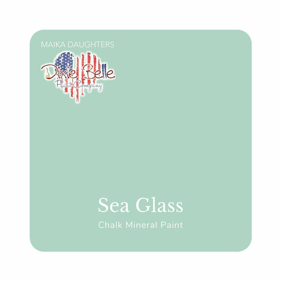 A square swatch card of Dixie Belle Paint Company’s Sea Glass Chalk Mineral Paint is against a white background. This color is a blue light gray.