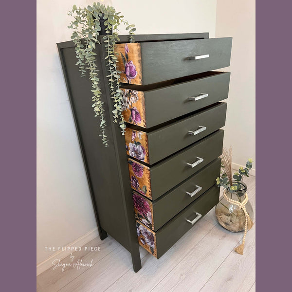 A 6-drawer dresser refurbished by The Flipped Piece by Shayna Alnwick is painted a chocolate brown and features Buds and Branches against natural wood on the sides of the drawers.