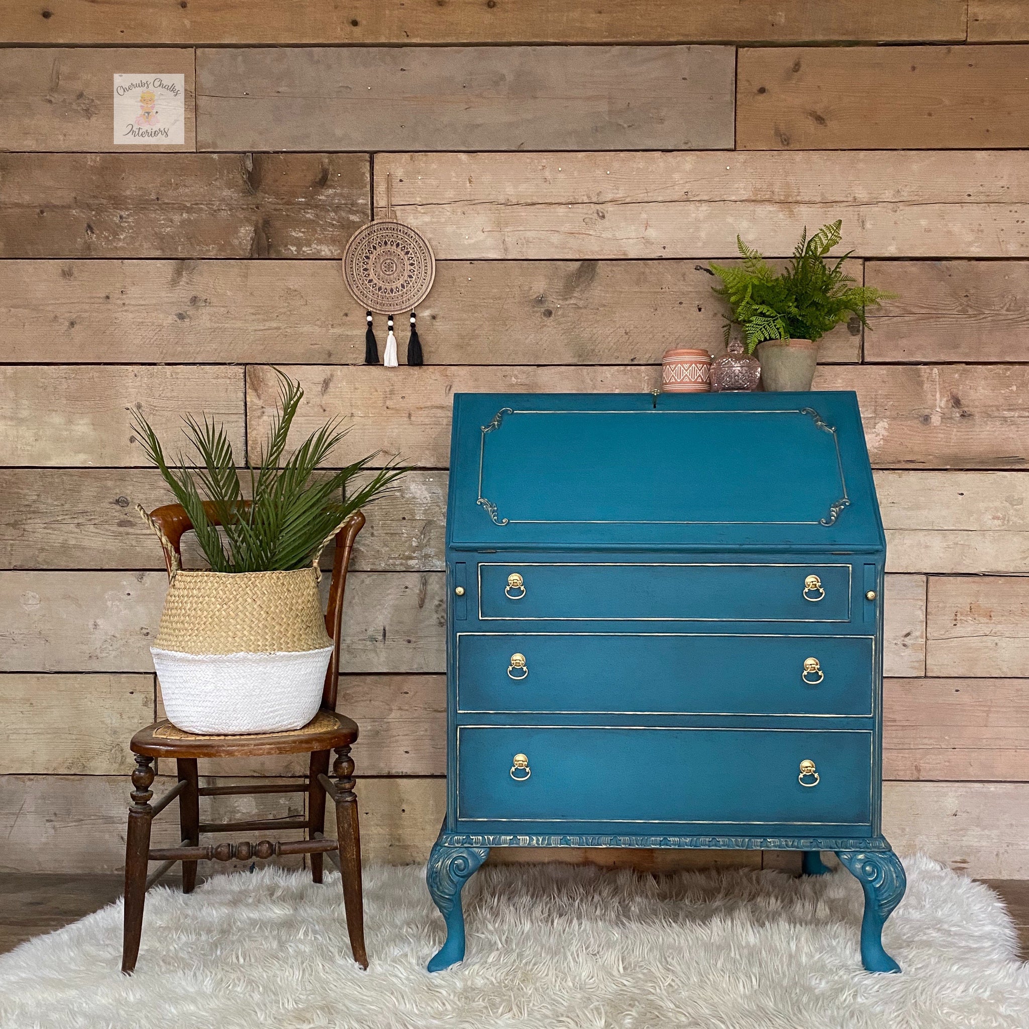 A vintage secretary's desk with gold details refurbished by Cherubs Chalks Interiors is painted in Dixie Belle's Antebellum Blue chalk mineral paint.