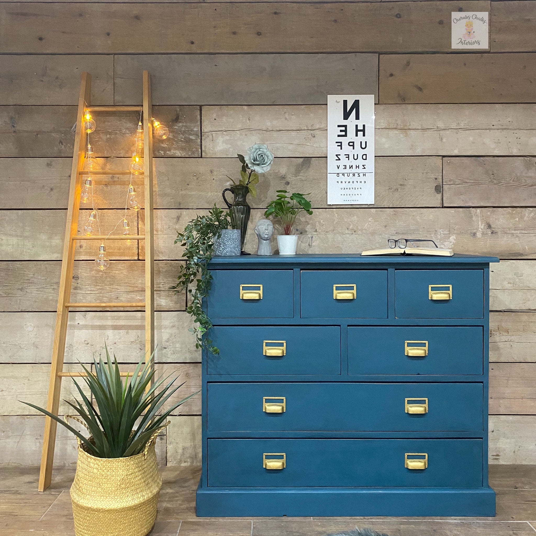 A vintage 7-drawer dresser with gold drawer pulls refurbished by Cherubs Chalks Interiors is painted with Dixie Belle's Antebellum Blue chalk mineral paint.