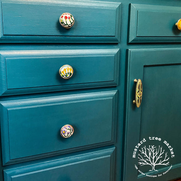 A close-up of a dresser refurbished by Mustard Tree Market is painted with Dixie Belle's Antebellum Blue chalk mineral paint.