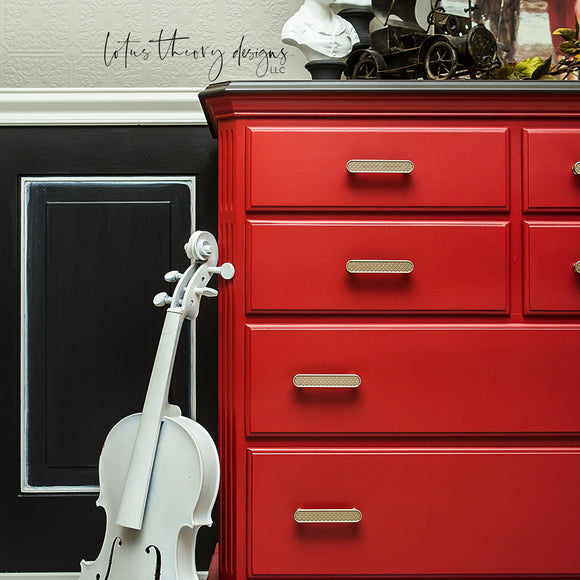 A close-up of a large dresser refurbished by Lotus Theory Designs LLC is painted with Dixie Belle's Barn Red chalk mineral paint.