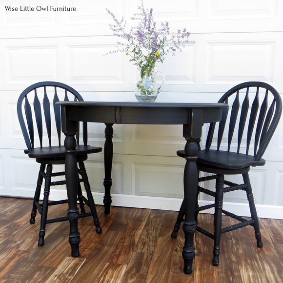 A vintage wood table and chairs refurbished by Wise Little Owl Furniture are painted in Dixie Belle's Caviar chalk mineral paint.