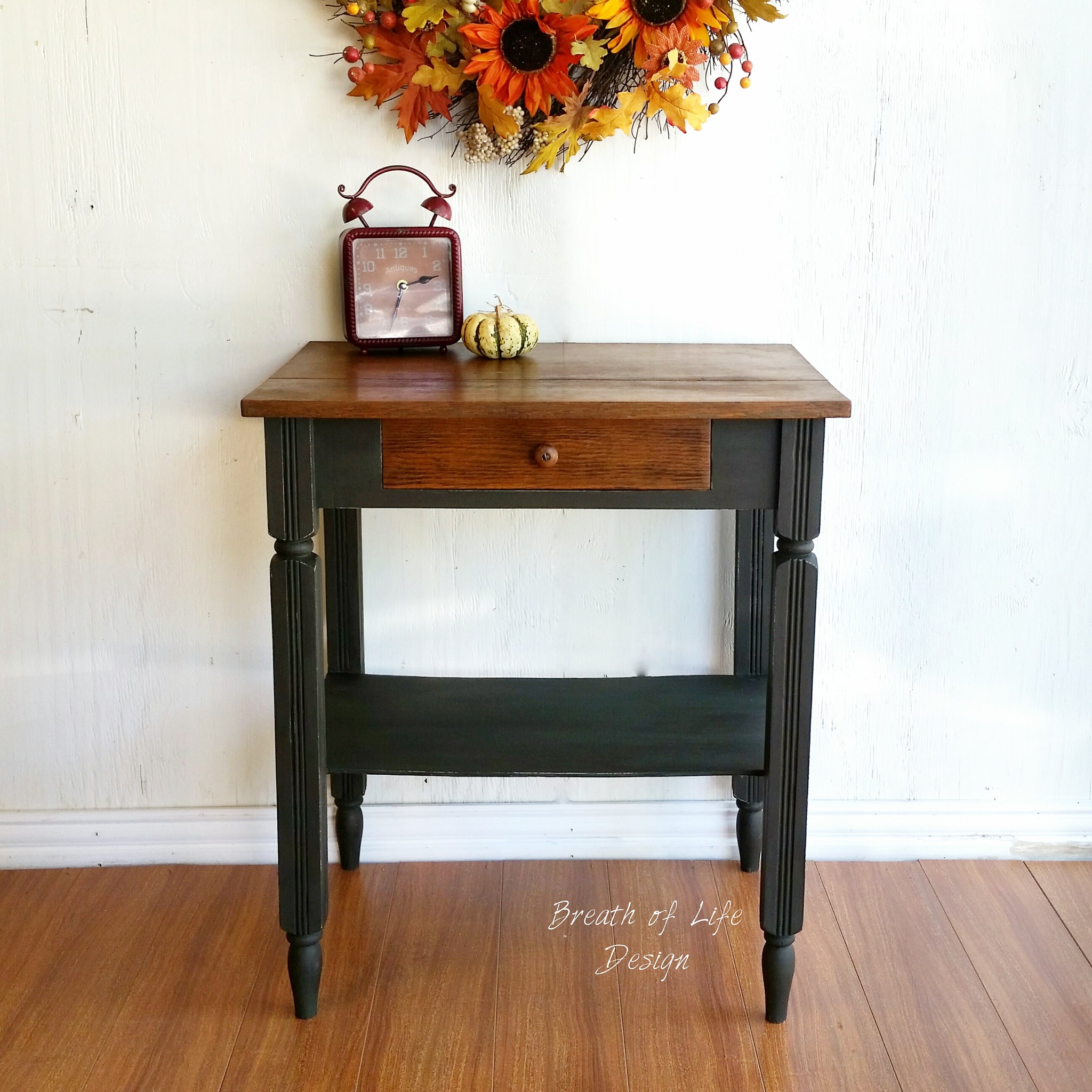 A vintage small entry-way table refurbished by Breath of Life Design is painted with Dixie Belle's Collard Greens chalk mineral paint and has a natural wood desktop and small drawer.