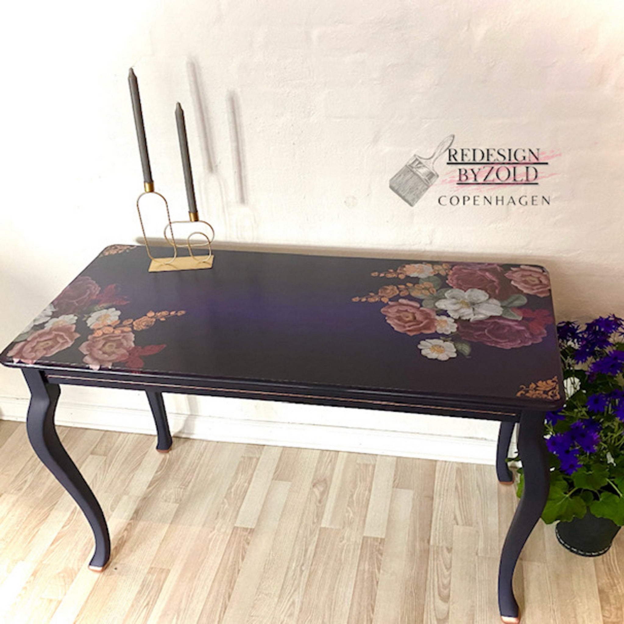 A vintage table refurbished by Redesign by Zold Copenhagen is painted midnight blue and features the Floral Romance transfer on the top.