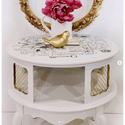 A white round coffee table with the Lovely Ledger transfer on top.