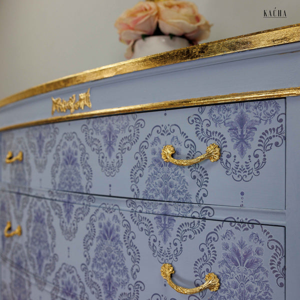 Close-up of a dresser refurbished by Kacha is painted light blue with gold accents and features the Kacha Dana Damask trasnfer on its drawers.