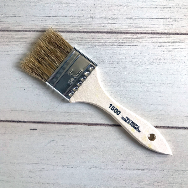 An arial view of a paint brush on a table. On it, it says 2", 50.8mm. 1500. Pure bristle. Made in Indonesia. 