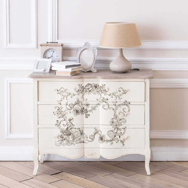A vintage 3-drawer dresser is painted a soft white and feature the Alaina Toile transfer on its drawers.