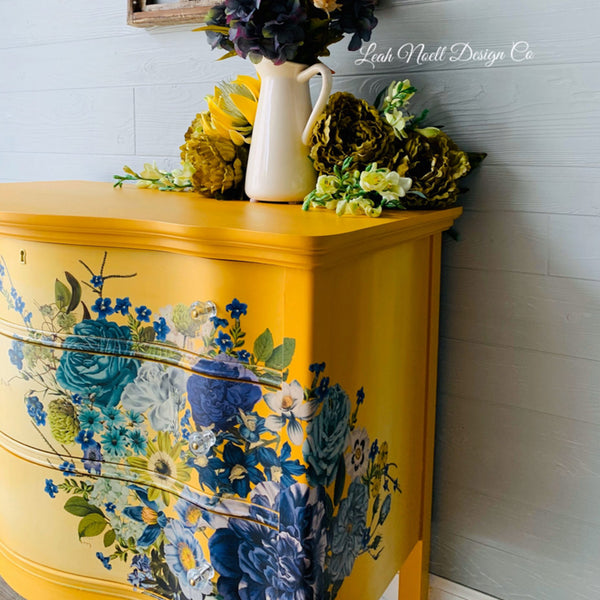 Close-up of a vintage dresser refurbished by Leah Noell Design Co. is painted mustard yellow and features the Cosmic Roses transfer on its drawers.