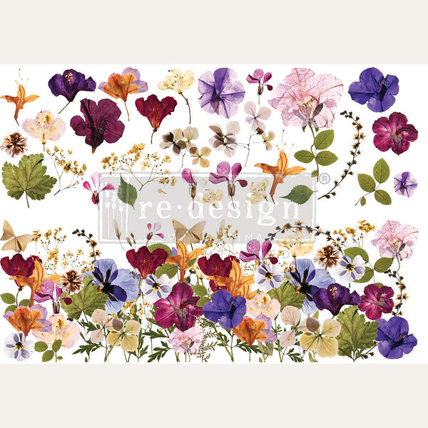 Rub-on transfer design of colorful pressed flowers. Light beige borders are on the top and bottom.