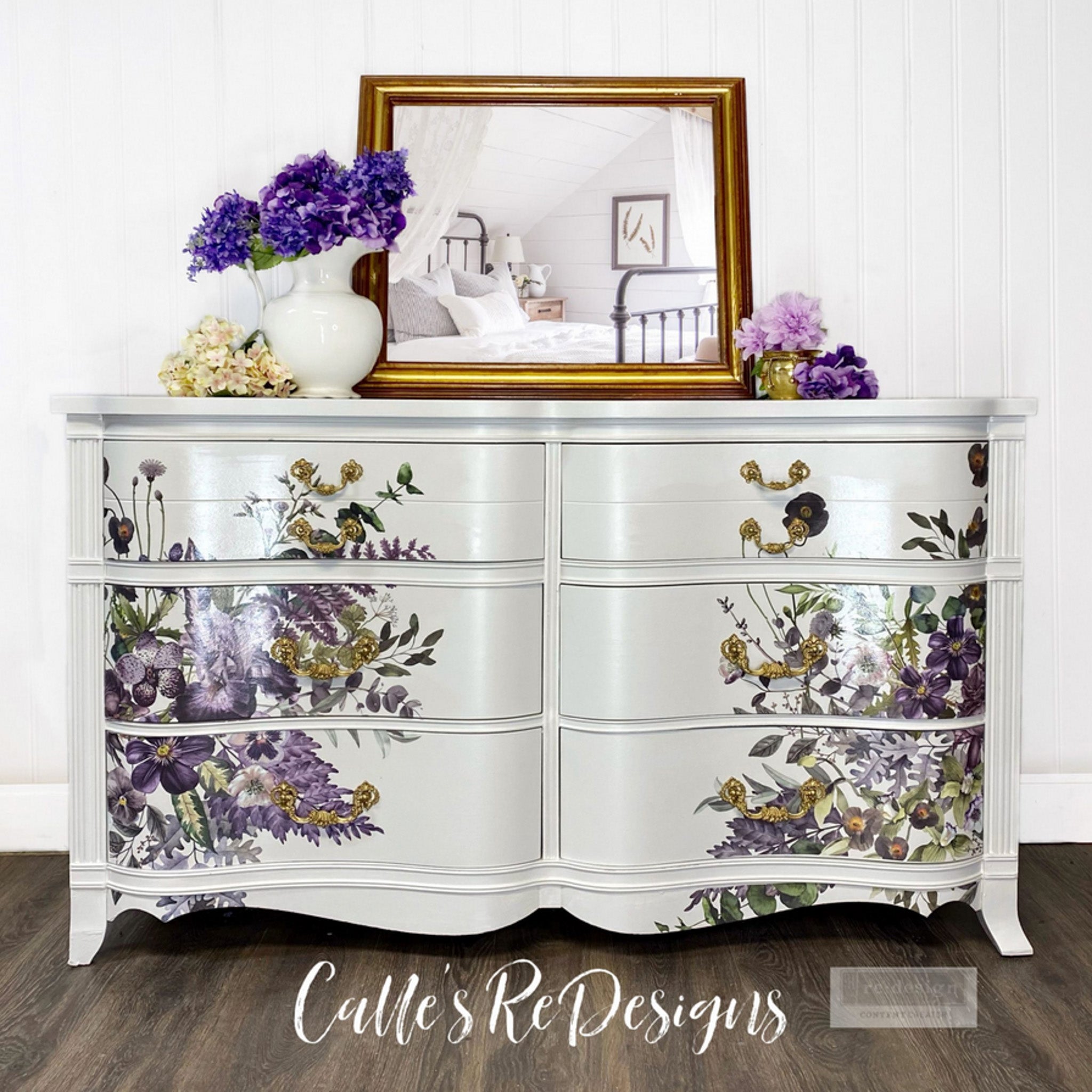 A vintage dresser refurbished by Calle's ReDesigns is painted white and features ReDesign with Prima's Vigrous Violet transfer on its drawers.