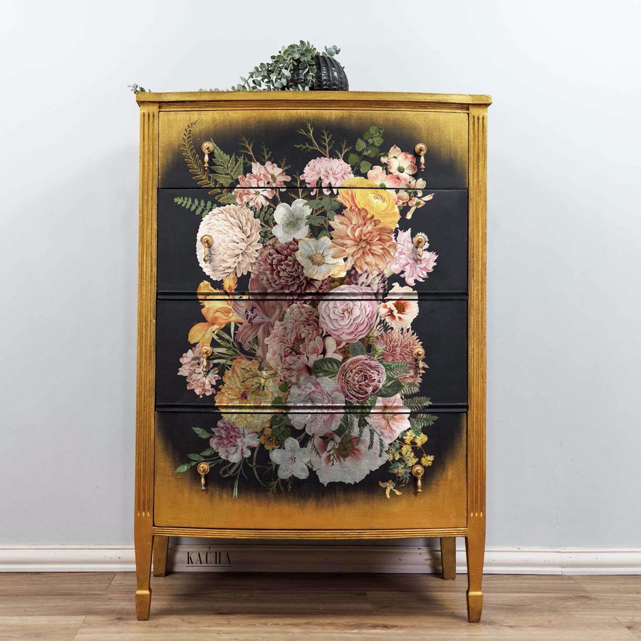 A 4-drawer chest dresser refurbished by Kacha is stained a natural wood color. The center of the front of the drawers is painted black with soft edges and features ReDesign with Prima's Kacha Woodland Floral transfer.