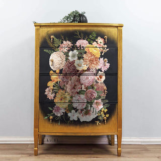 A 4-drawer chest dresser refurbished by Kacha is stained a natural wood color. The center of the front of the drawers is painted black with soft edges and features the Kacha Woodland Floral transfer.