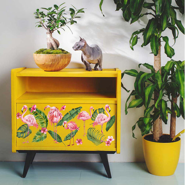 A vintage side table is painted bright mustard yellow and features the Flamingo Pink small transfer on it.