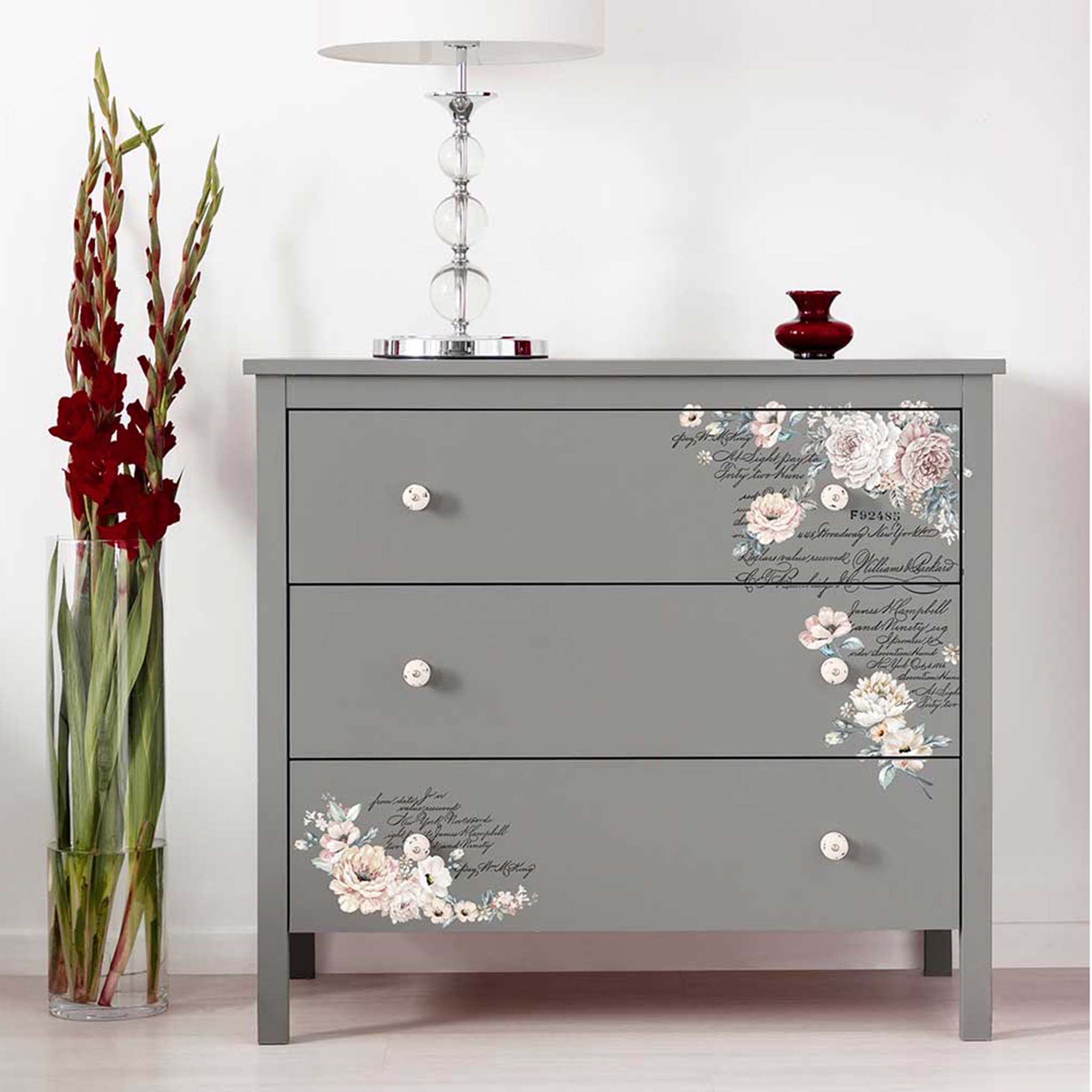 A grey 3-drawer dresser features ReDesign with Prima's Natural Wonders small transfer on the bottom left and top right corners of the top and bottom drawers.