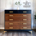 A vintage dresser refurbished by The Grandson's Brush is painted black with natural wood stain on all but the top 2 drawers and features ReDesign with Prima's Midcentury Vibes stencil in black on the natural stained drawers.