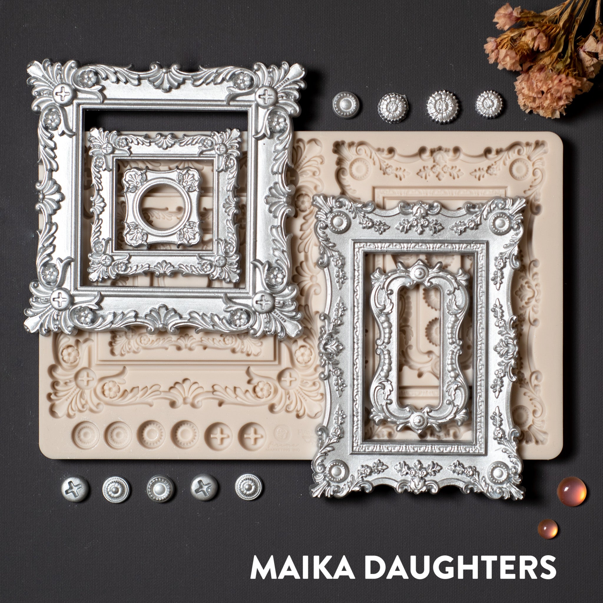 A light tan silicone mould and silver painted castitngs of Finnabair's Baroque Frames are on a dark grey background.