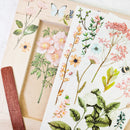 A wood picture frame project, wood craft stick, and 2 sheets of the Botanical Paradise trasnfer are against a white background.