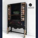 A vintage cabinet refurbished by Flipped & Chipped Co. is painted black with gold accents and features the Classic Peach Flowers small transfer on it.