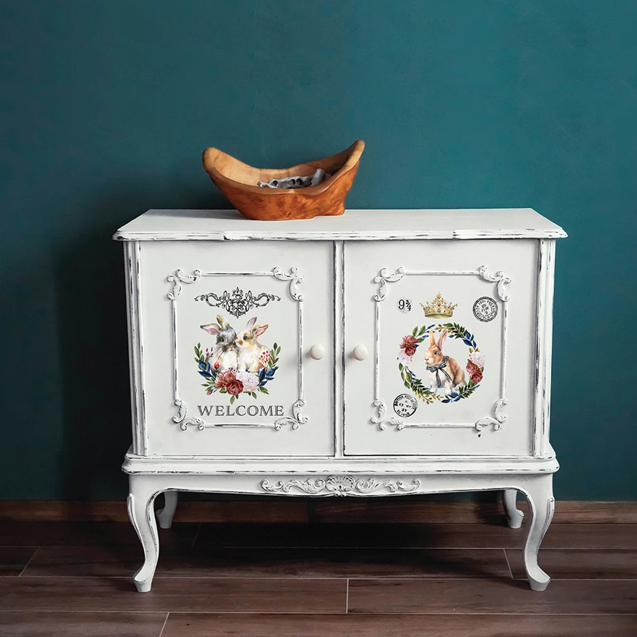 A vintage 2-door cabinet side table is painted white and features the Cottontail small transfer on it.