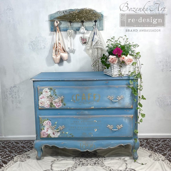 A vintage 2-drawer nightstand refurbished by Bozenka Art, a ReDesign with Prima Brand Ambassador, is painted blue and features the Delicate Roses small transfer on its drawers.